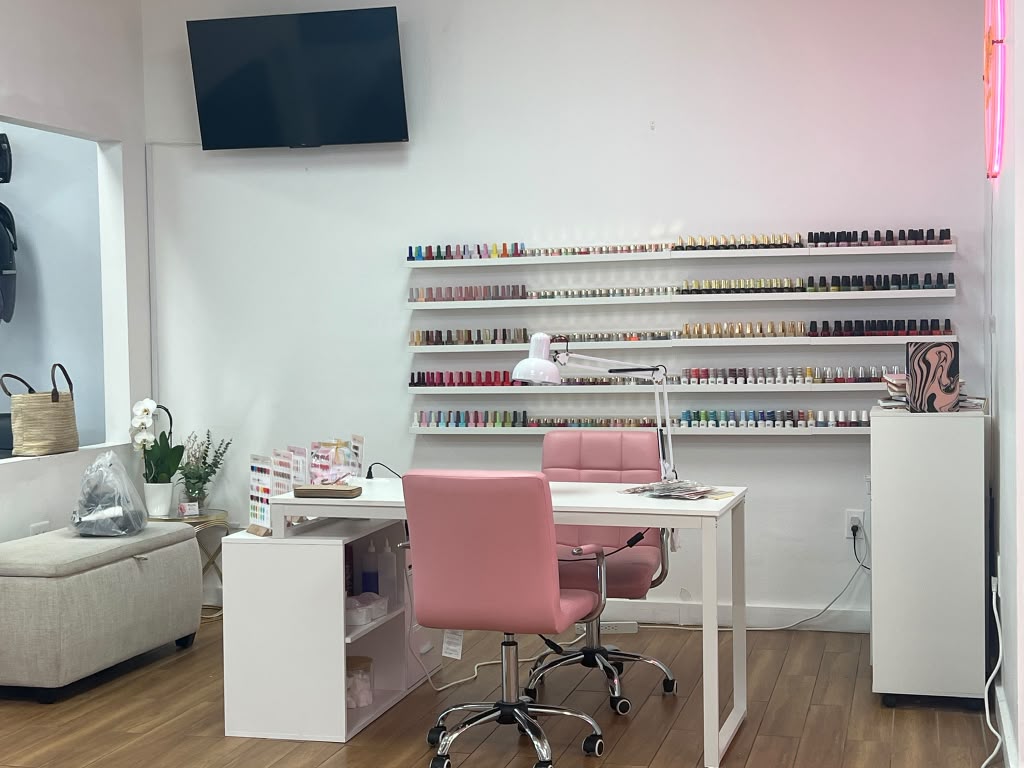 Salon nail station with pink chairs and polish display